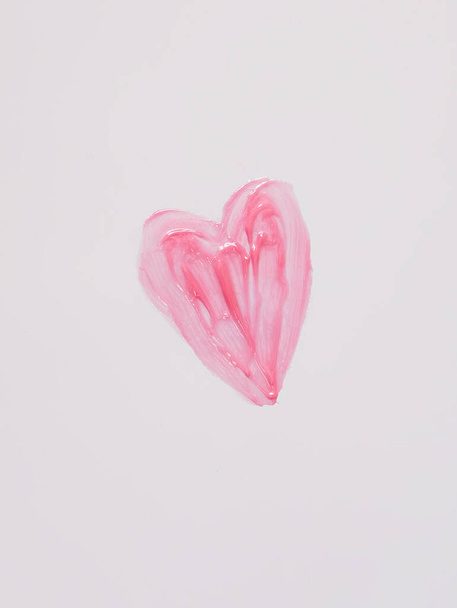 Χειροποίητο σχήμα της καρδιάς. Δείγμα ροζ lip gloss σε λευκό φόντο. - Φωτογραφία, εικόνα