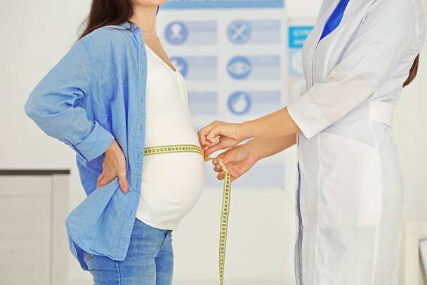 Doctor measuring pregnant belly - Fotoğraf, Görsel