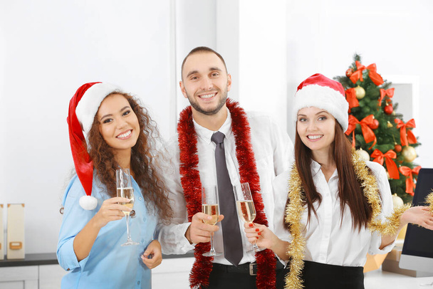 Νέοι άνθρωποι που γιορτάζει τα Χριστούγεννα στο εταιρικό πάρτι στο γραφείο - Φωτογραφία, εικόνα