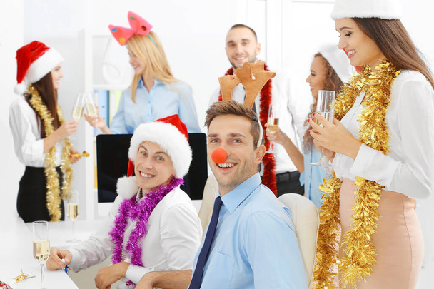 Młodzi ludzie świętują Boże Narodzenie na firmowej imprezie w biurze - Zdjęcie, obraz