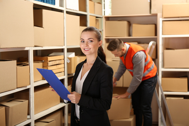 Young businesswoman with clipboard at warehouse - Photo, Image