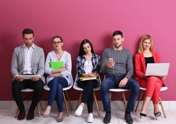 Renkli arka planda iş görüşmesi bekleyen bir grup insan - Fotoğraf, Görsel