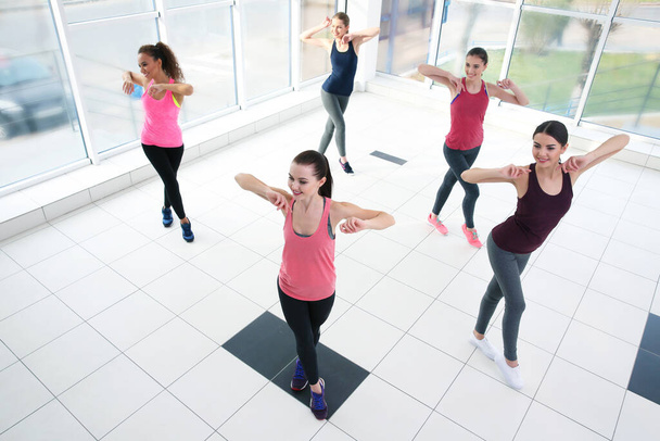 Jovens mulheres esportivas treinando em salão de dança
 - Foto, Imagem