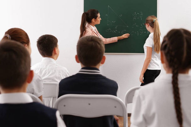 Жінка-вчителька проводить урок у класі
 - Фото, зображення