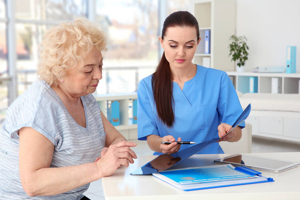 Orthopädin untersucht Seniorin in Klinik - Foto, Bild