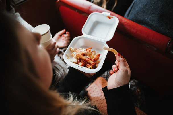 photo of a woman eating fries with ketchup - Foto, Imagen