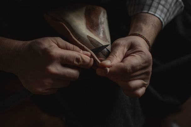 Las manos del zapatero en el trabajo hacen la suela para zapatos nuevos hechos a mano. El proceso de creación de zapatos - Foto, imagen