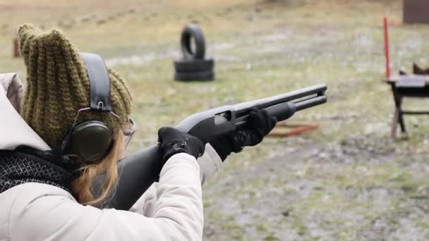A lány vadászpuskával lő a lőtéren lévő célpontokra. 12 kaliber - Felvétel, videó