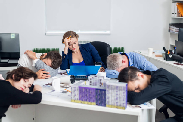 Verveelde of vermoeide zakenmensen slapen, rusten op hun werkplek tijdens de vergadering, een concept van uitgeputte zakenmensen vervelen, slapen, moe - Foto, afbeelding