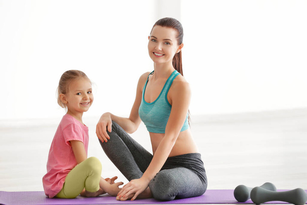 Mother and daughter sitting in gym - Photo, Image