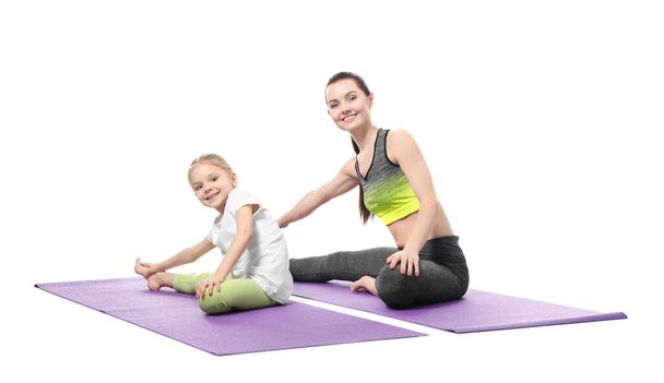 Mother and daughter doing exercise on white background - Zdjęcie, obraz