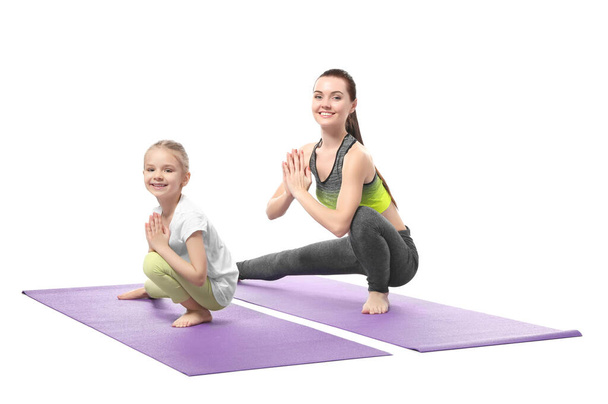 Mother and daughter doing exercise on white background - Photo, Image