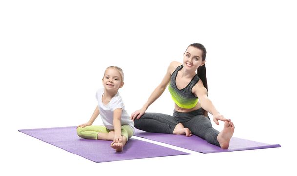 Mother and daughter doing exercise on white background - Fotoğraf, Görsel
