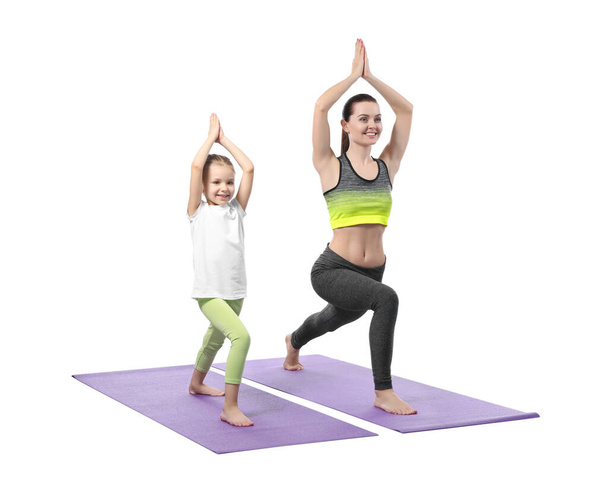 Mother and daughter doing exercise on white background - Photo, image