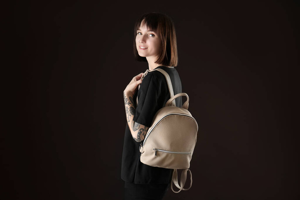 Young woman with leather backpack on black background - Photo, Image