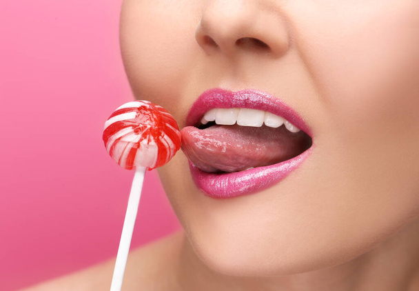 Lips of beautiful young woman with lollipop, closeup - Foto, Imagen