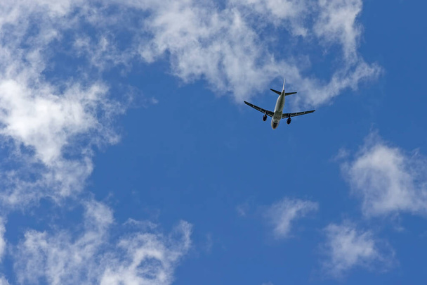 Airplane flies against a background of blue sky. - Foto, imagen