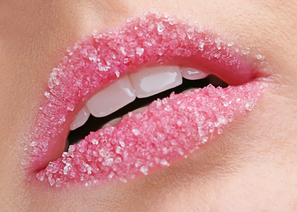 Lippen van mooie jonge vrouw bedekt met suiker, close-up - Foto, afbeelding