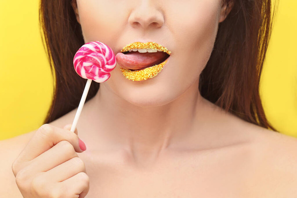 Lips of beautiful young woman with creative makeup and lollipop, closeup - Foto, Bild