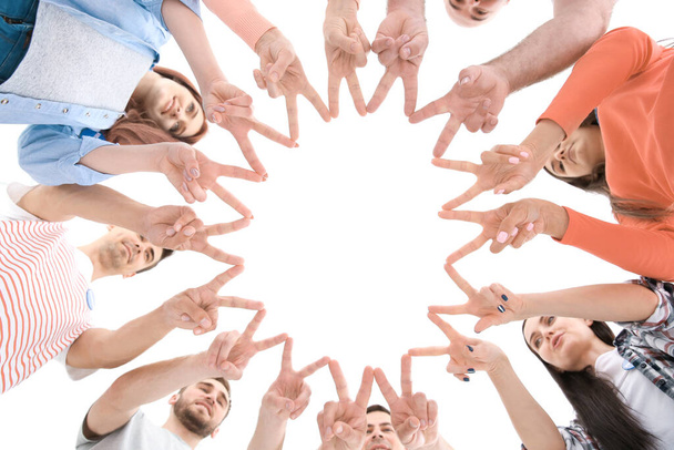 Grupo de jóvenes voluntarios haciendo círculo con sus manos sobre fondo blanco
 - Foto, Imagen