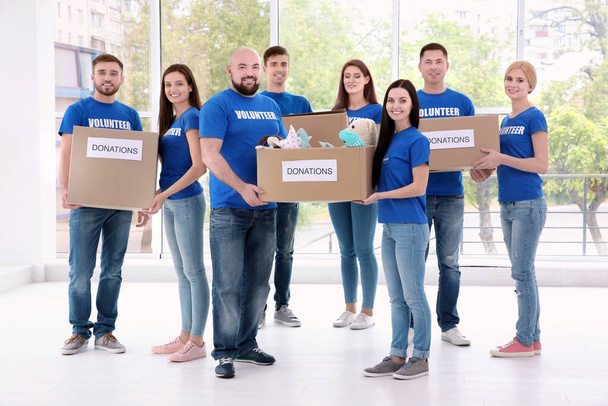 Молодые добровольцы с коробками пожертвований в помещении
 - Фото, изображение
