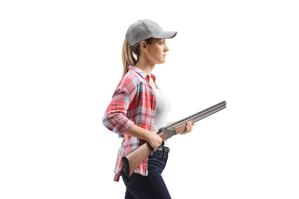 Dangerous female walking with a shotgun isolated on white background - Foto, imagen