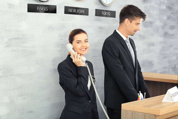 Female and male receptionists working in hotel - Фото, изображение