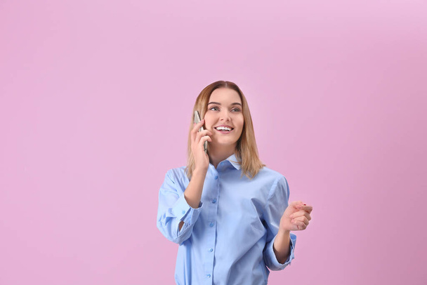 Young woman using cell phone on pink background - Photo, Image