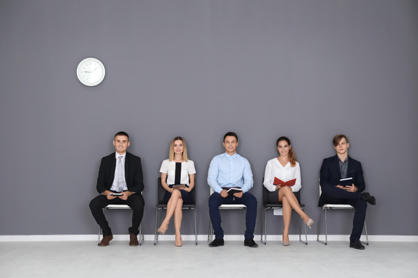 Grupo de personas a la espera de entrevista de trabajo en fondo gris de la pared
 - Foto, imagen