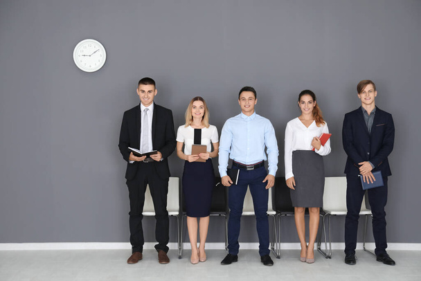 Group of people waiting for job interview on gray wall background - Foto, Imagem