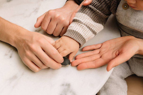Father and mother holding kid hand. Child hand closeup into parents - Fotoğraf, Görsel