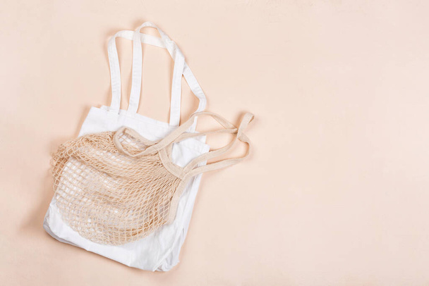 Cotton reusable bag on a beige canvas background. Eco-friendly concept. Flat lay, copy space - Fotó, kép