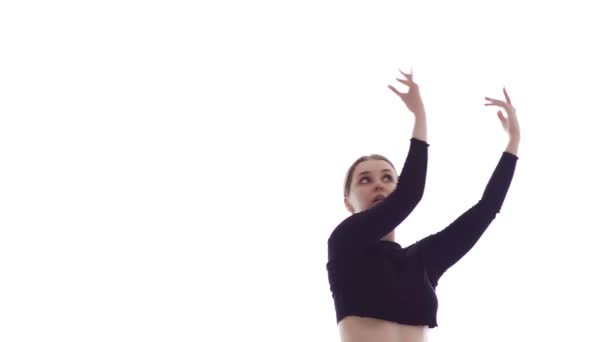 Mediano tiro largo de joven hermosa bailarina en top corto negro y polainas negras emocionalmente bailando danza contemporánea, danza de ballet moderna, aislado
 - Metraje, vídeo