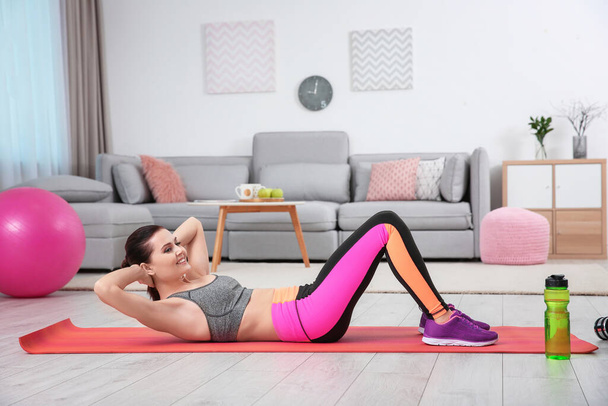 Young sporty woman doing exercise at home - Photo, Image