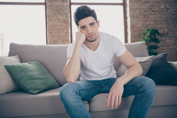 Portrait of his he nice attractive depressed dumped guy sitting on divan feeling bad after party waiting friends at modern industrial loft brick interior style living-room - Фото, зображення