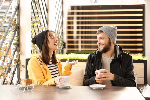 Trendy hipster couple sitting together in modern cafe - Fotografie, Obrázek