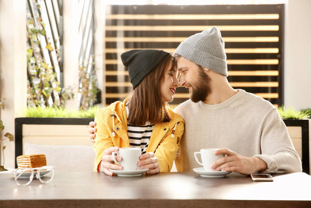 Trendy hipster couple sitting together in modern cafe - Fotó, kép