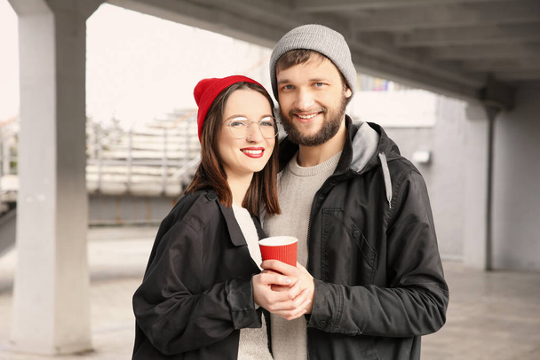 Trendy hipster couple with cup of coffee outdoors - Photo, Image
