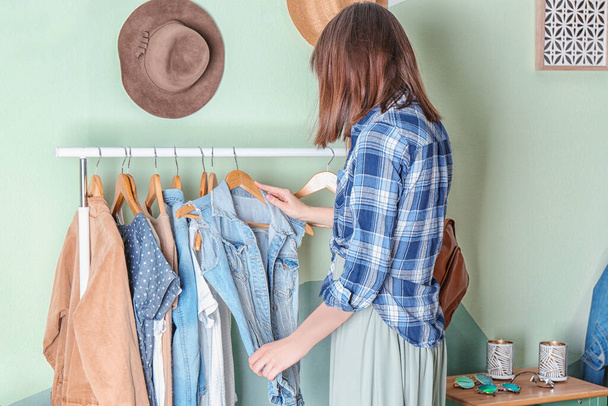Kobieta wybierając ubrania na stojaku w garderobie - Zdjęcie, obraz