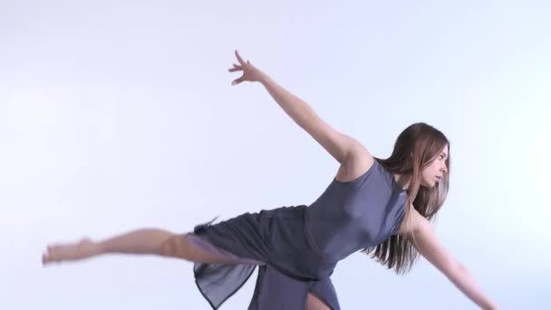 Medium long shot of young beautiful woman dancer in a dress with long hair emotionally dancing contemporary, modern ballet dance, slow motion, isolated - Filmati, video