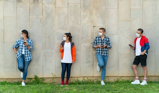 Έφηβοι στέλνουν μηνύματα κινητής τηλεφωνίας στον αστικό τοίχο - Φωτογραφία, εικόνα