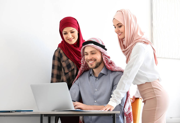 Empresário muçulmano com colegas de trabalho no cargo
 - Foto, Imagem