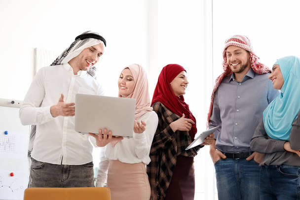 Empleados de oficina musulmanes con ropa tradicional que tienen reuniones de negocios en interiores
 - Foto, Imagen