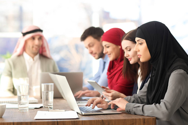 Pracownicy biurowi i ich muzułmańscy współpracownicy mający spotkanie biznesowe w biurze - Zdjęcie, obraz