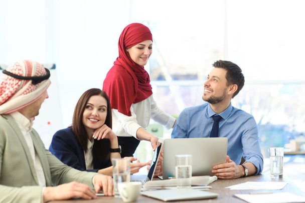 Kancelářské zaměstnance a jejich muslimské spolupracovníky, kteří mají obchodní jednání v úřadu - Fotografie, Obrázek