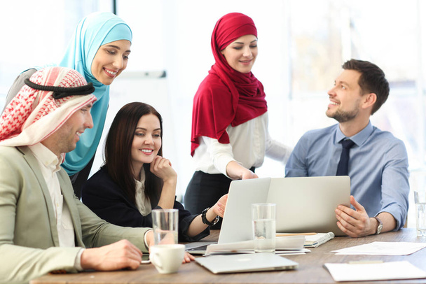 Office employees and their Muslim coworkers having business meeting in office - Фото, зображення