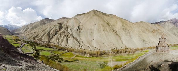 Panorama de Stock La valley en Ladak, Jammu y Cachemira, India, con santuario budista mirando sobre un campo de cultivo verde y montañas
 - Foto, imagen