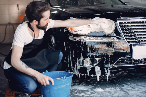 Man washing his car in a garage - 写真・画像