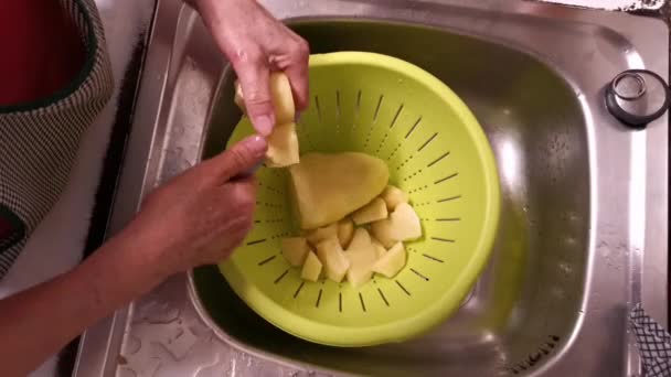 Oudere dame hakt aardappelen in een kom - Video