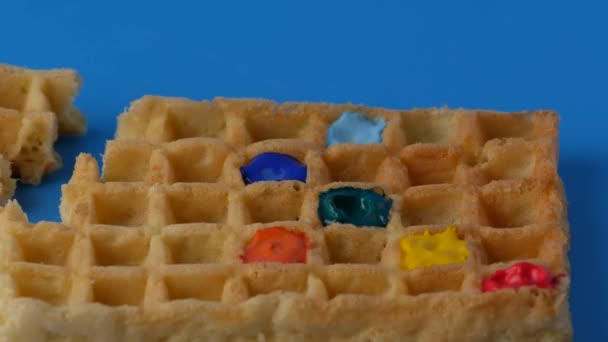 Rotating sweet colored belgian waffles on a blue background. - Filmati, video